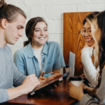 Diverse group of international students talking and supporting each other over coffee
