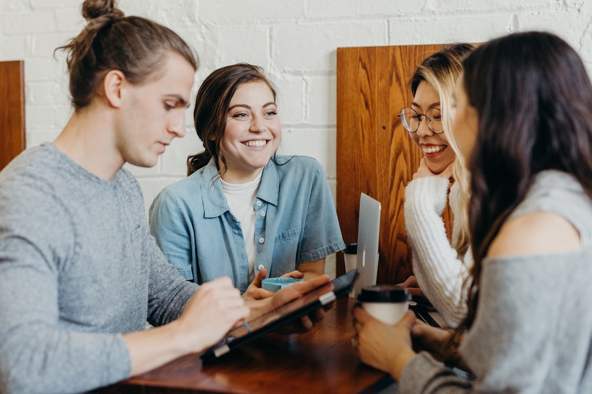 Diverse group of international students talking and supporting each other over coffee