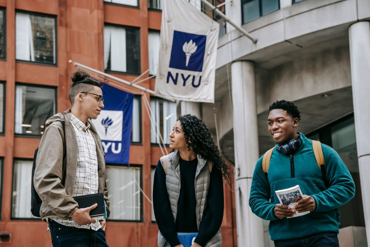 Diverse international F-1 students discussing outside a university building