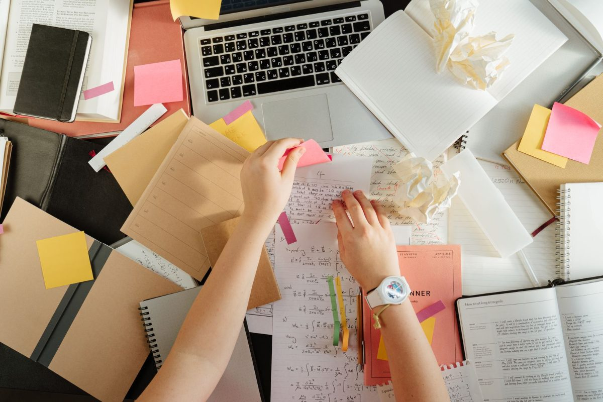 Student organizing F-1 visa paperwork and deadlines with a laptop and notes