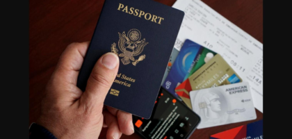 Hand holding a US passport with travel documents, representing the F-1 Duration of Status rule for international students