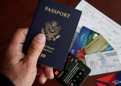 Hand holding a US passport with travel documents, representing the F-1 Duration of Status rule for international students