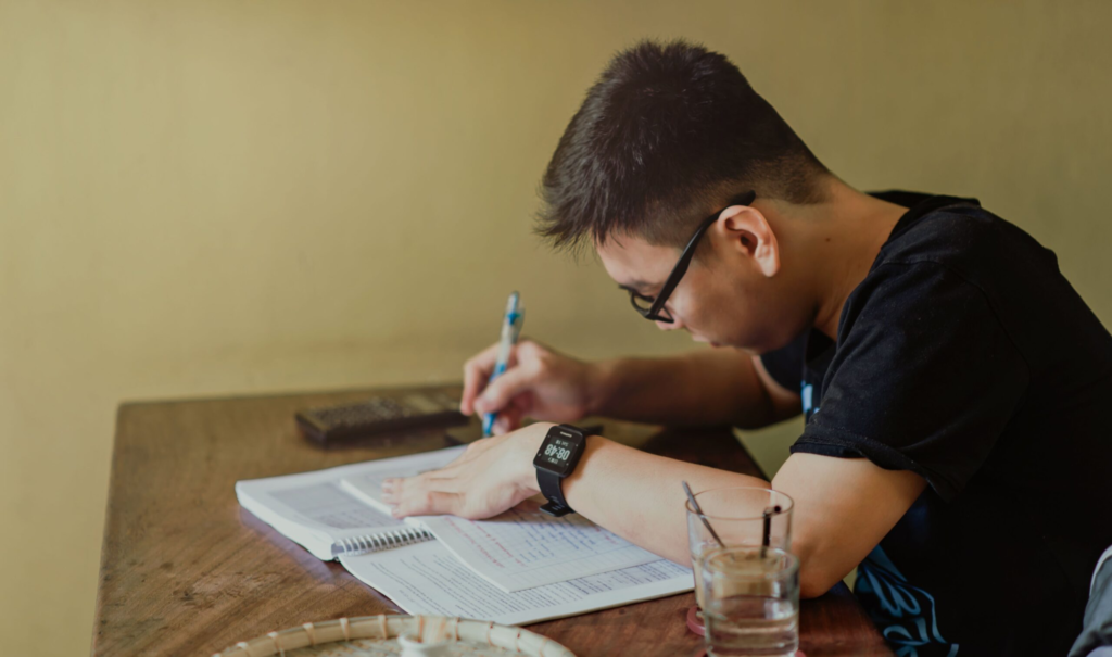 Indian student writing and studying, preparing a study abroad application despite backlogs