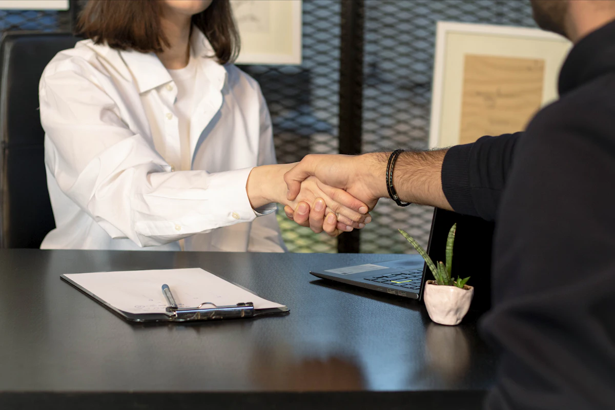 Graduate shaking hands at a job interview during the APS RECE search period in France