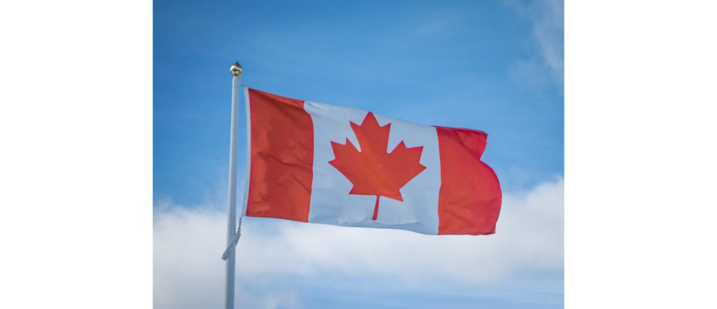 Canadian flag waving against a blue sky, representing Canada study permit applications