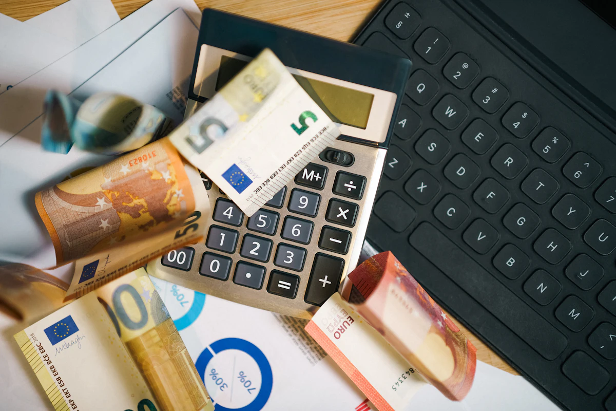Calculator resting on euro notes, showing the cost to study in France 2026