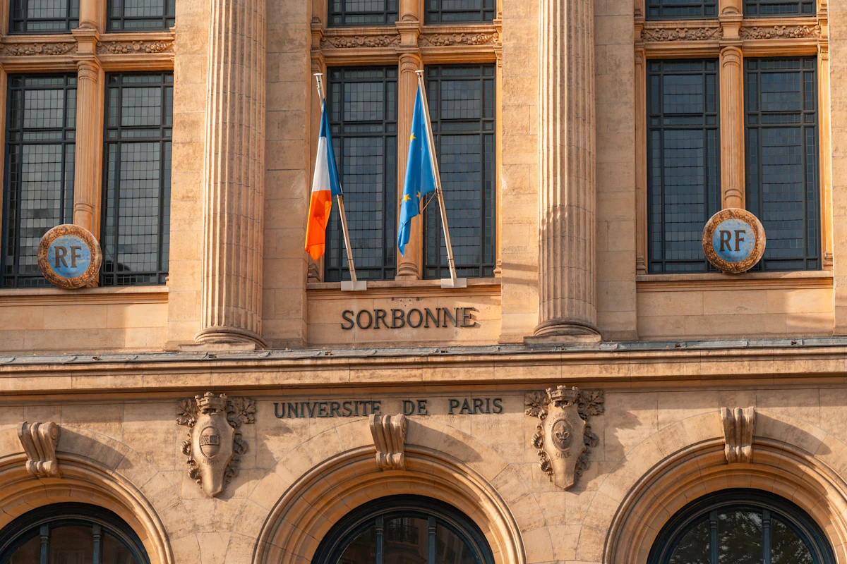 Sorbonne university building in Paris with French flags on the facade