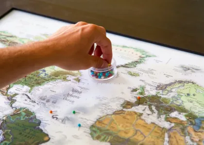 Student placing pins on a world map to choose a country to study abroad