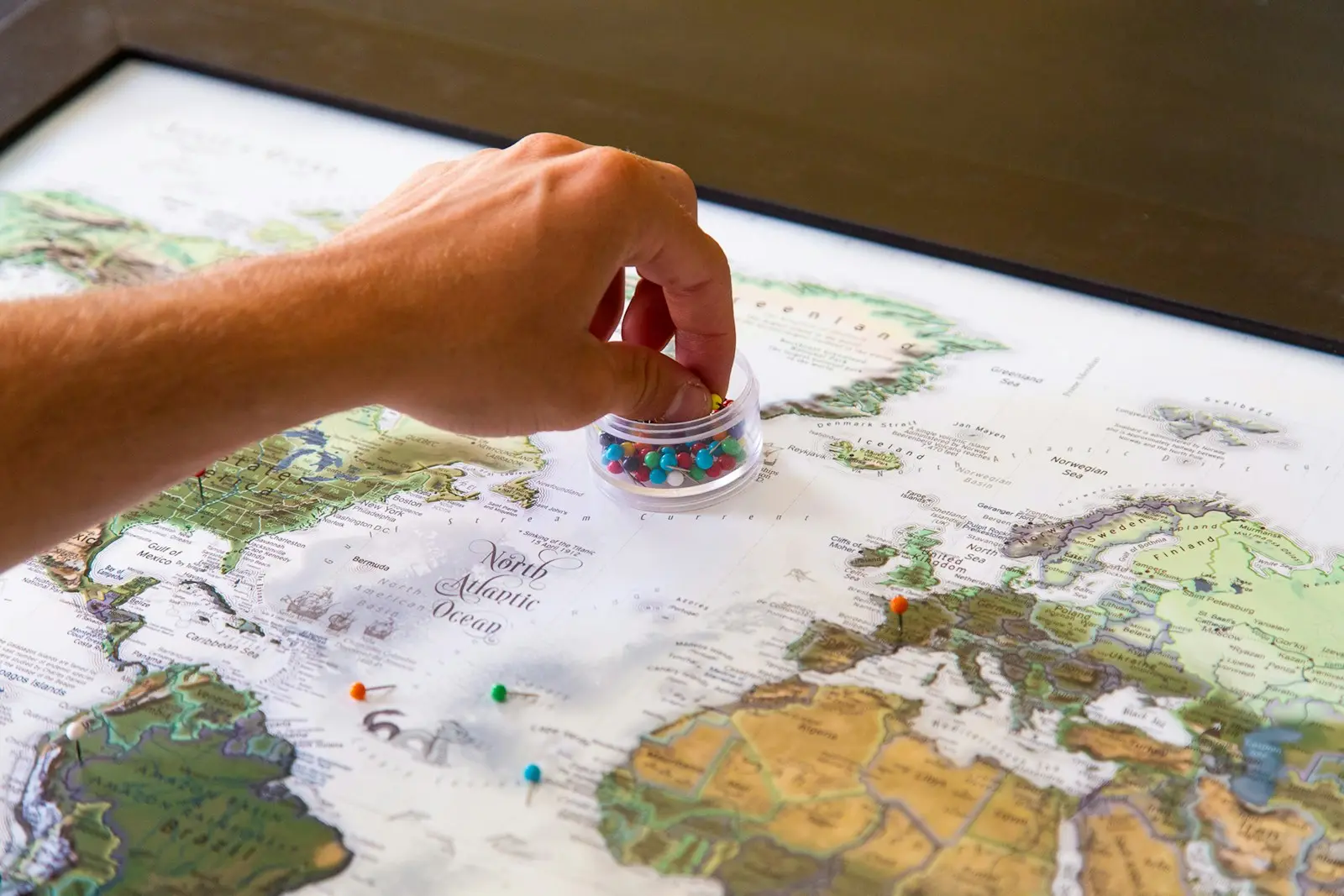 Student placing pins on a world map to choose a country to study abroad