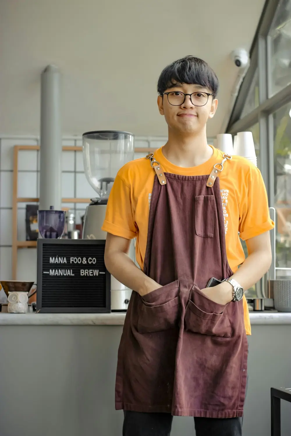 Smiling student in an apron at a part-time cafe job